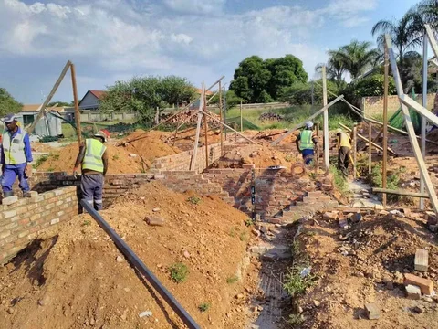 Construction team installing pipework in an excavated trench